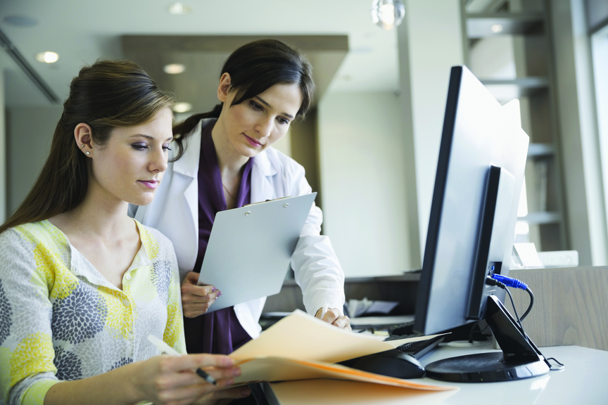 Dentist and receptionist reviewing information
